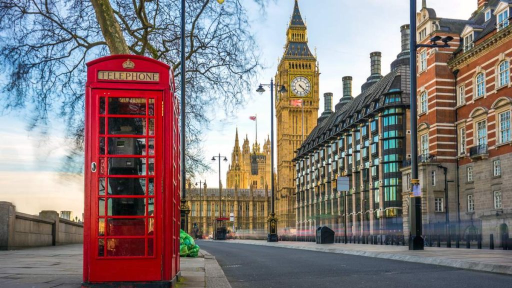 A icônica caixa de telefone vermelha britânica antiga, com o Big Ben ao fundo, no centro de Londres - Inglaterra