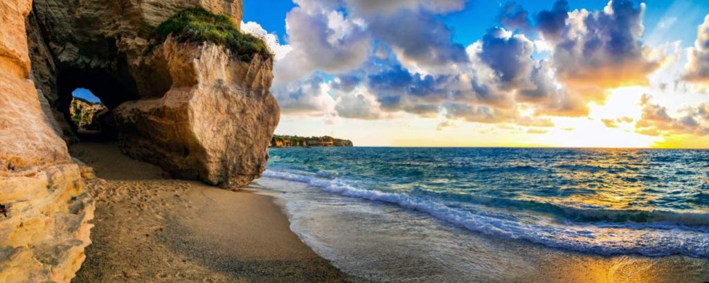 Incrível pôr do sol do mar na pequena praia escondida em Tropea, Calábria, Itália.