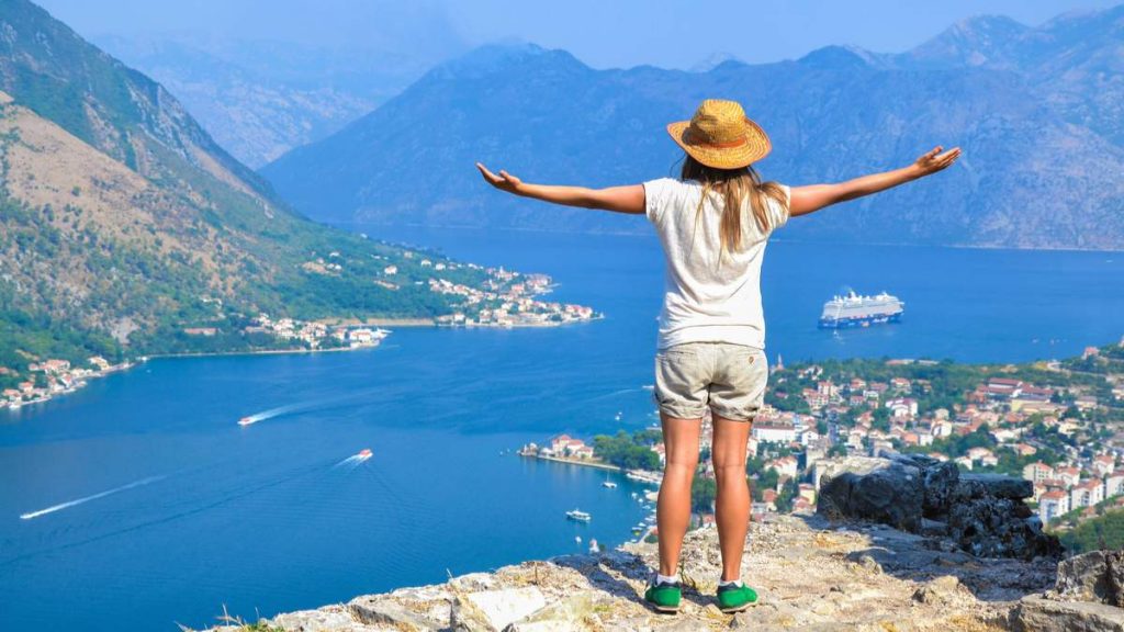 Mulher jovem turista, desfrutando de uma vista da Baía de Kotor, Montenegro.